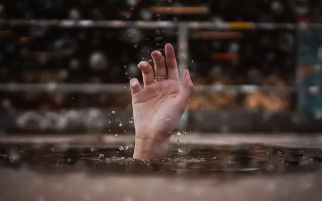 Ahimsa Görünmeyen Siddet Ahimsanın olmadığı yerde hissedilen çaresizliği temsilen suların içinden yükselen bir elin fotoğrafı.